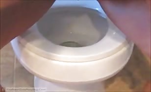 Shaved girl shitting over toilet