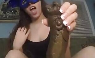 Masked brunette girl playing with her monster turd 